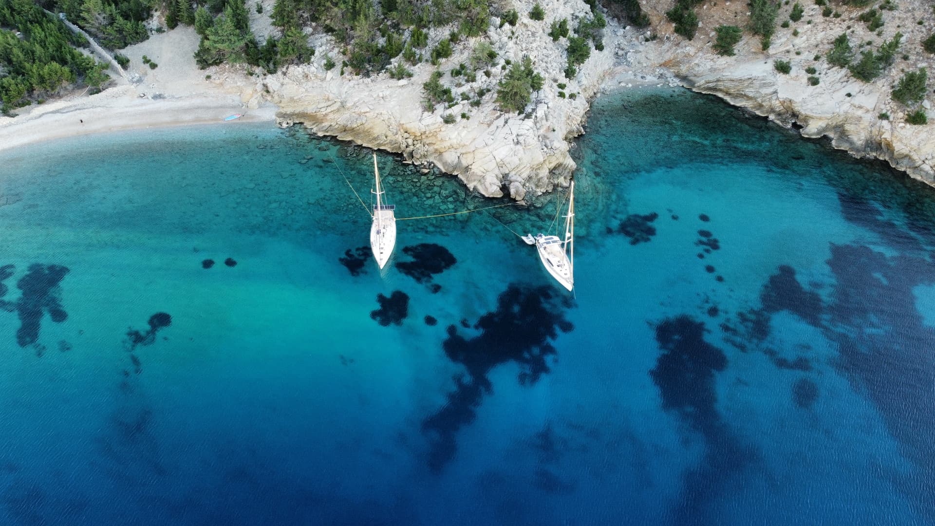 Topas at anchor in a turquoise Mediterranean bay, seen from above
