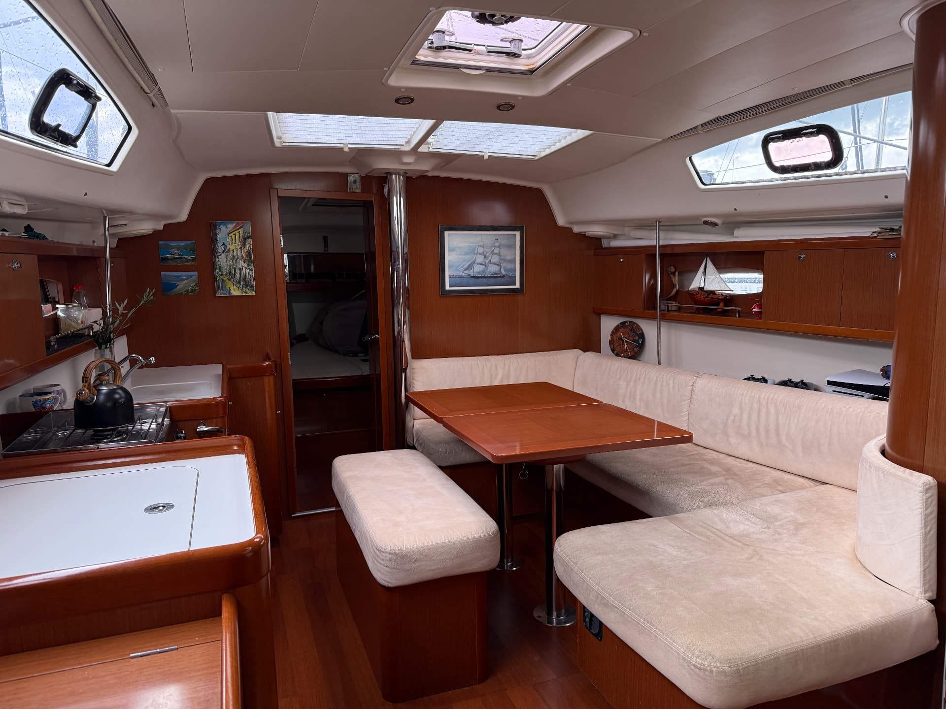 Topas saloon with dining table, galley and natural light